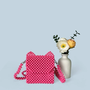 Détail d'un sac à bandoulière en perles fait main avec design oreilles de chat en rose vif