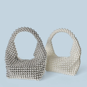 Detail of handmade beaded hobo bags in silver metallic and elegant white pearl finish