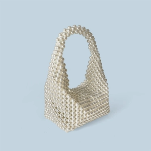 Detail view of handmade white faux pearl beaded Boston bag with structural woven handle