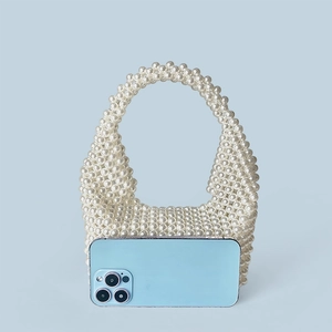 Detailed comparison of mini handmade pearl beaded handbag next to a smartphone
