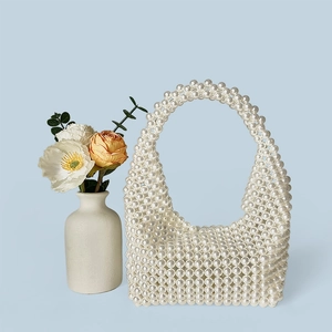 Detailed texture of white faux pearl woven handbag for elegant wedding banquets