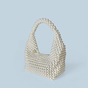 Detailed close-up of handmade white faux pearl weave on a Boston style handbag