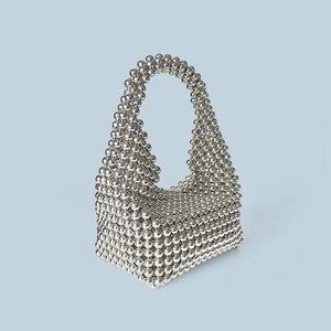 Macro detail of a silver beaded Boston bag showing glossy metallic texture and weaving