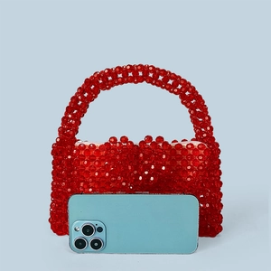 Détail du sac à main rouge perlé avec texture tissée et doublure blanche zippée interne