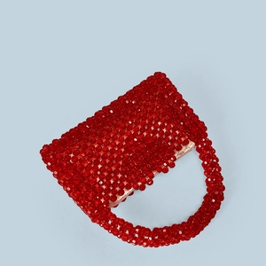 Détail d'un sac à main en perles rouges tissées avec doublure en satin rose doux