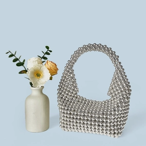 Detail of silver beaded handbag with handcrafted metal weave and seamless top handle