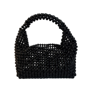 Detail of handmade black beaded boston bag showing woven resin beads and arched handle