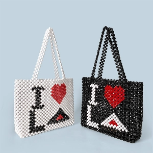 Detail of handmade beaded tote bags featuring contrast heart and I LA letter patterns