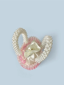 Macro detail of pink crystal beaded bag with faux pearl handles and satin drawstring pouch