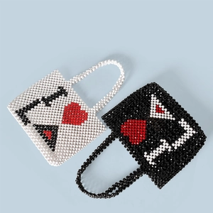 Close-up of handmade beaded handbags featuring red hearts and letter patterns