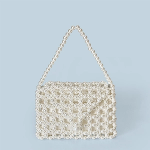 Close-up of handmade faux pearl beaded handbag with intricate woven patterns and satin lining