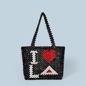 Detail of hand-woven black beaded tote bag featuring I Heart LA letter pattern