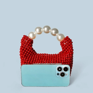 Détail d'un mini sac à main rouge perlé fait main avec poignée en perles et taille de référence