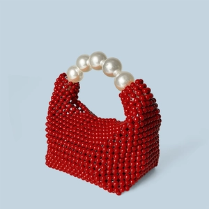Détails du sac à main rouge perlé avec une grande poignée en perles blanches élégantes