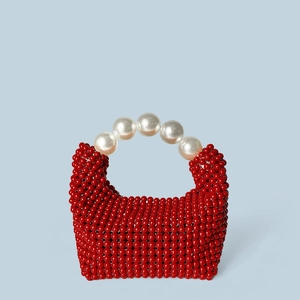 Détail du sac à perles rouges avec texture vintage et grandes anses en perles blanches