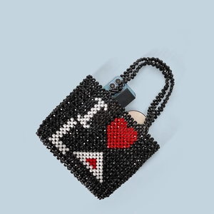 Detail of handmade beaded tote with contrast heart pattern showing beads texture
