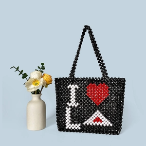 Detail of handmade beaded tote bag with heart and LA letters on blue background