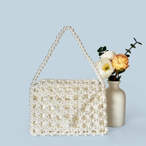 Detail of handmade woven pearl evening bag featuring intricate diamond bead patterns