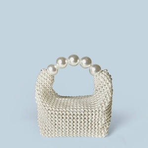 Détail d'un sac à main fait main en perles crème avec poignée à larges billes tressées