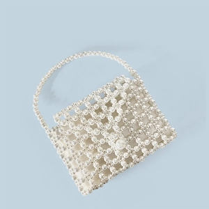 Detail view of handmade pearl beaded handbag with woven texture and satin lining