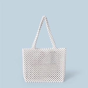 Close-up of a handmade white beaded tote bag featuring faceted beads and elegant handles