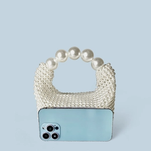 Gros plan d'un sac à main artisanal en perles blanches avec grande poignée de perles