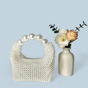 Gros plan détaillé d'un sac à main tissé en perles avec une grande poignée en perles