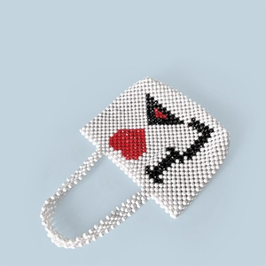 Close-up of handmade beaded handbag showing red heart and black letter pattern details
