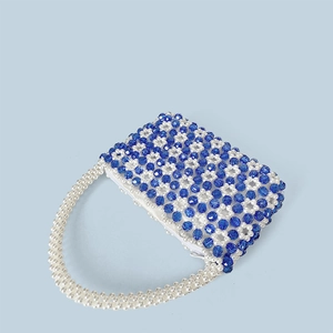 Detailansicht der handgefertigten Perltasche mit blauen Blumenmustern und Perlengriff