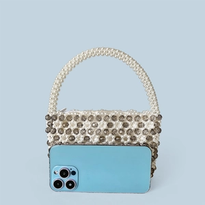 Detaillierter Größenvergleich der Perlenhandtasche neben einem modernen Smartphone