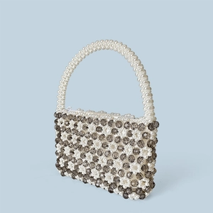 Detailansicht der handgefertigten Perlenhandtasche mit Blumenmuster und weißem Reißverschluss