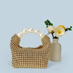 Détail du sac à main fait main avec perles dorées et grande poignée en perles élégantes