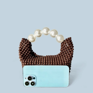 Détail du sac à main en perles marron avec anse en perles blanches et comparaison de taille