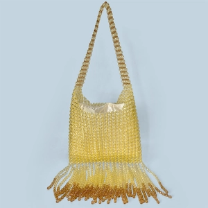 Detail of yellow amber gradient beaded bag with handmade tassels and satin lining