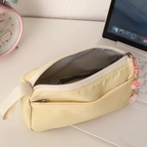 Detail of plush pencil case with zipper closure and cute pink cartoon charm