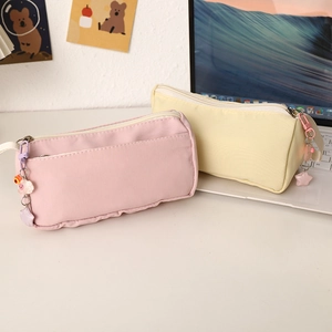 Close-up of pink and yellow plush stationery pouches with cute star and cartoon zipper charms