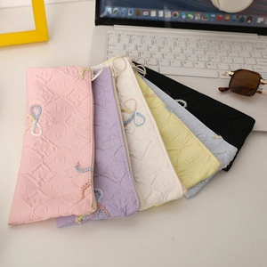 Detail of colorful quilted pencil cases with bow embroidery in various pastel shades