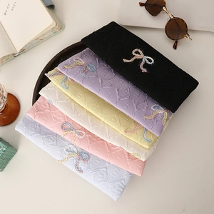 Close-up of six colorful knitted jacquard headbands with 3D bow details and diamond texture