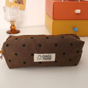 Detailed view of brown polka dot corduroy pencil case with zipper and bear patch