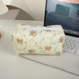 Detail einer gesteppten Kosmetiktasche mit floralem Muster und weißem Reißverschluss