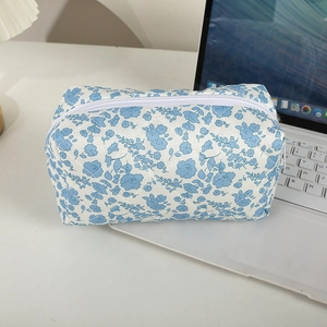 Detailaufnahme einer gesteppten Baumwolltasche mit Blumenmuster und weißem Reißverschluss