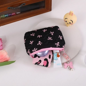 Quilted bow mini pouch with pearl charm showing interior cosmetics storage capacity