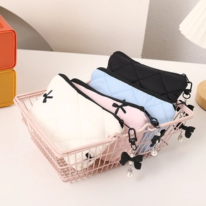Close-up of quilted bow makeup bags in pink shopping basket showing textures