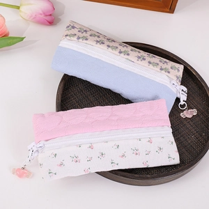 Quilted floral pencil cases in blue and pink with heart pendants on a vintage tray