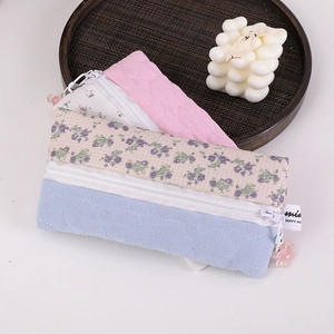 Detailed view of floral and quilted fabric pencil cases with beaded zipper pulls