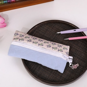Detail of floral canvas pencil case with heart quilting and cute pink charm