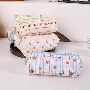 Primer plano de estuches de algodón acolchado con estampado floral y cremalleras metálicas