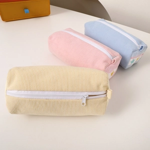 Macro view of waffle texture fabric pencil cases in yellow, pink, and blue with stars