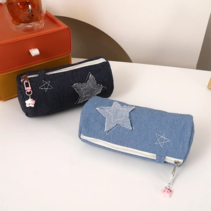 Detail of denim star pencil cases with embroidery and cute cartoon zipper pendants