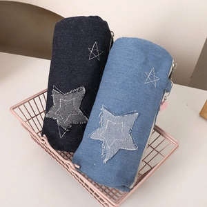 Detail of denim pencil cases with star patchwork and pink star zipper pulls in a basket